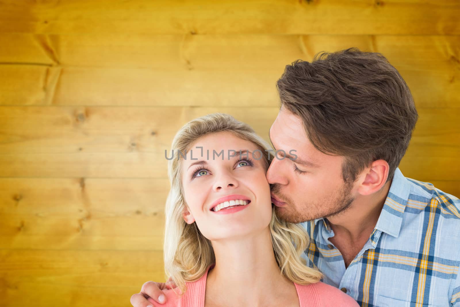 Composite image of handsome man kissing girlfriend on cheek by Wavebreakmedia