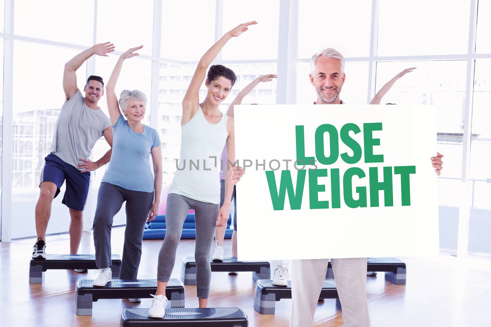 Smiling man showing large poster against lose weight