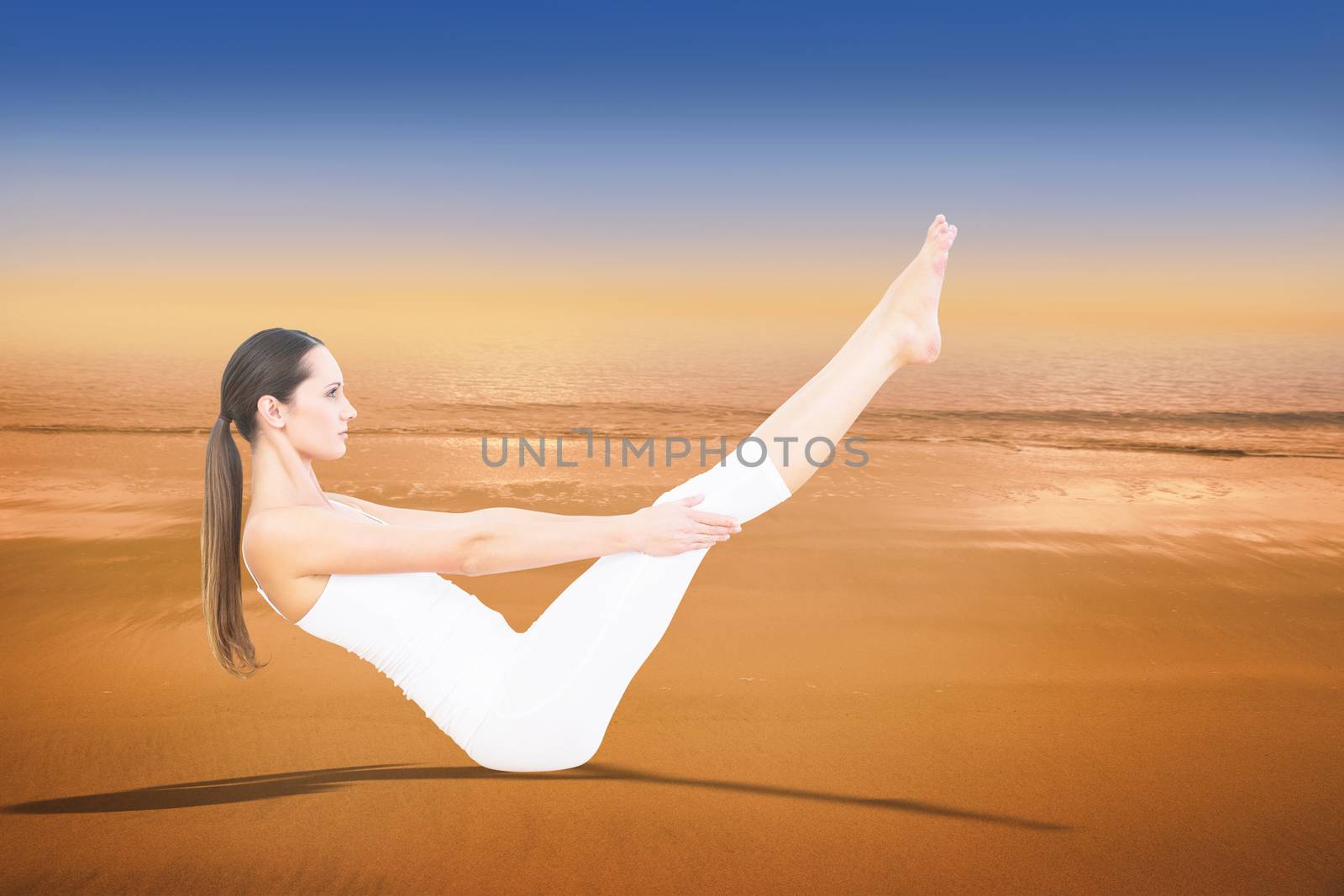 Toned woman doing the boat pose in fitness studio against hazy blue sky