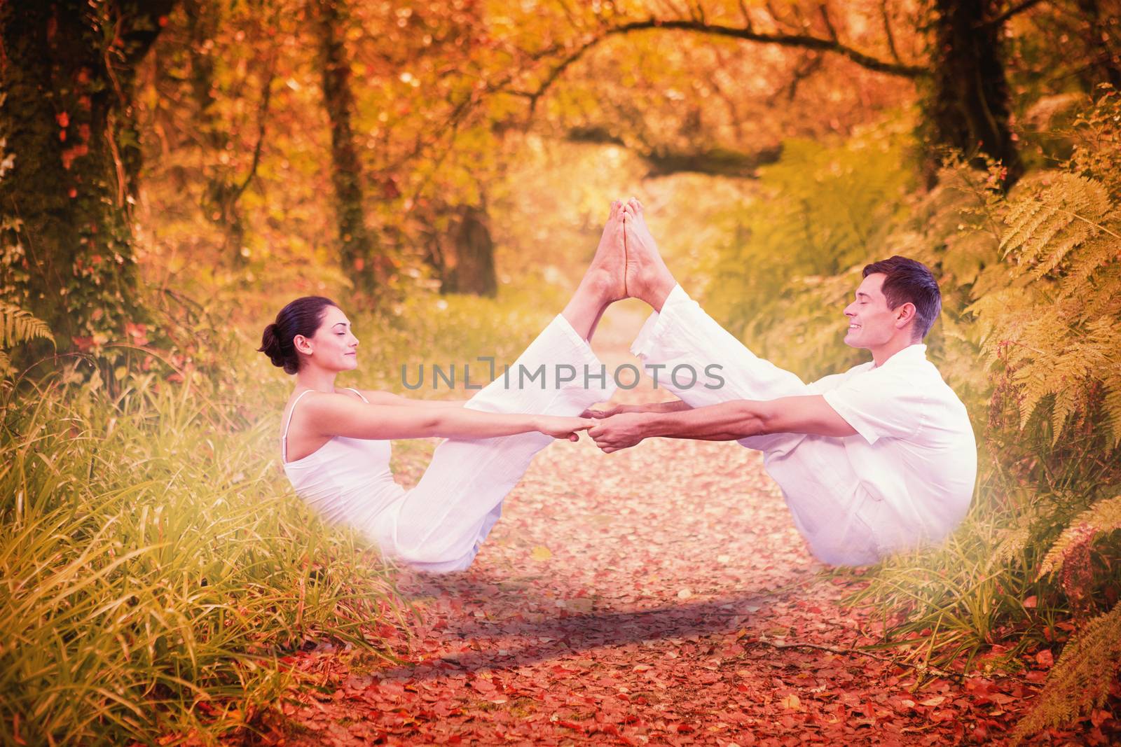 Peaceful couple sitting in boat position together against peaceful autumn scene in forest
