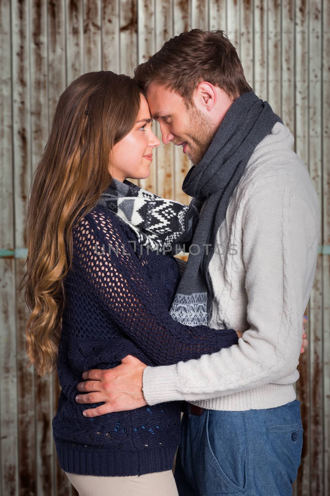 Side view of young couple embracing against wooden planks