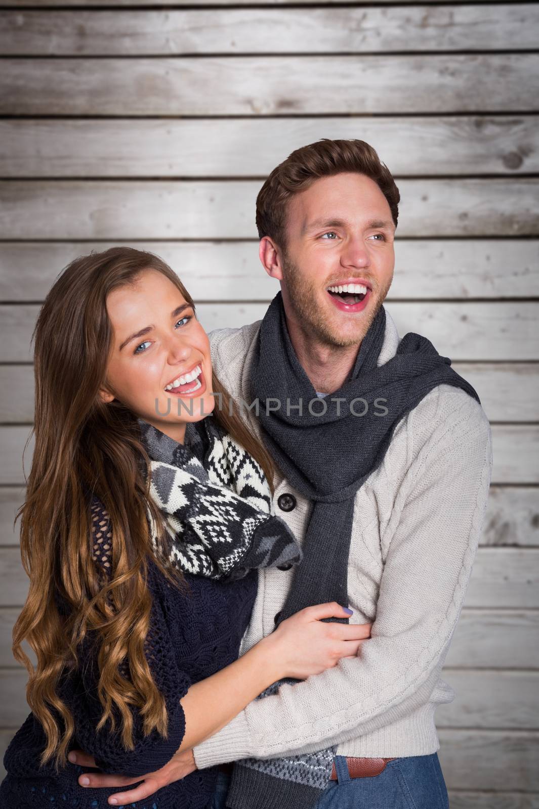Happy young couple embracing against wooden planks