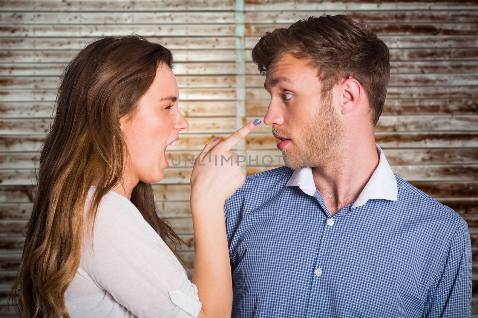 Casual young couple in an argument against wooden planks