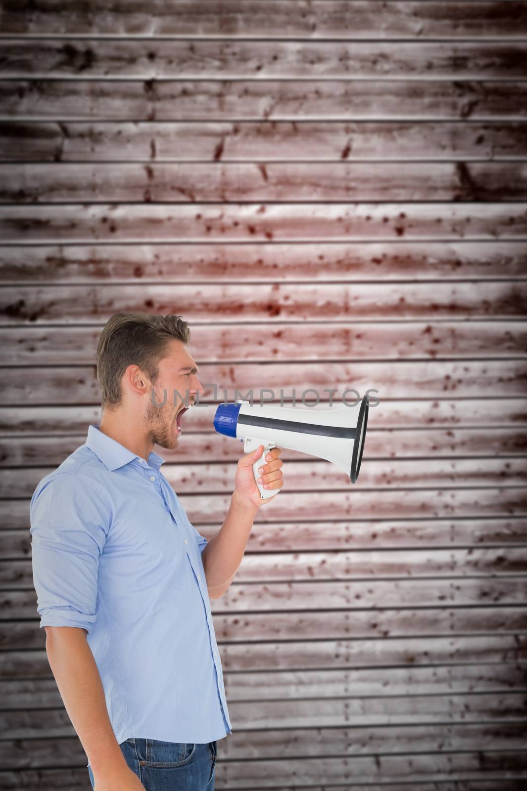 Angry man shouting through megaphone against wooden planks