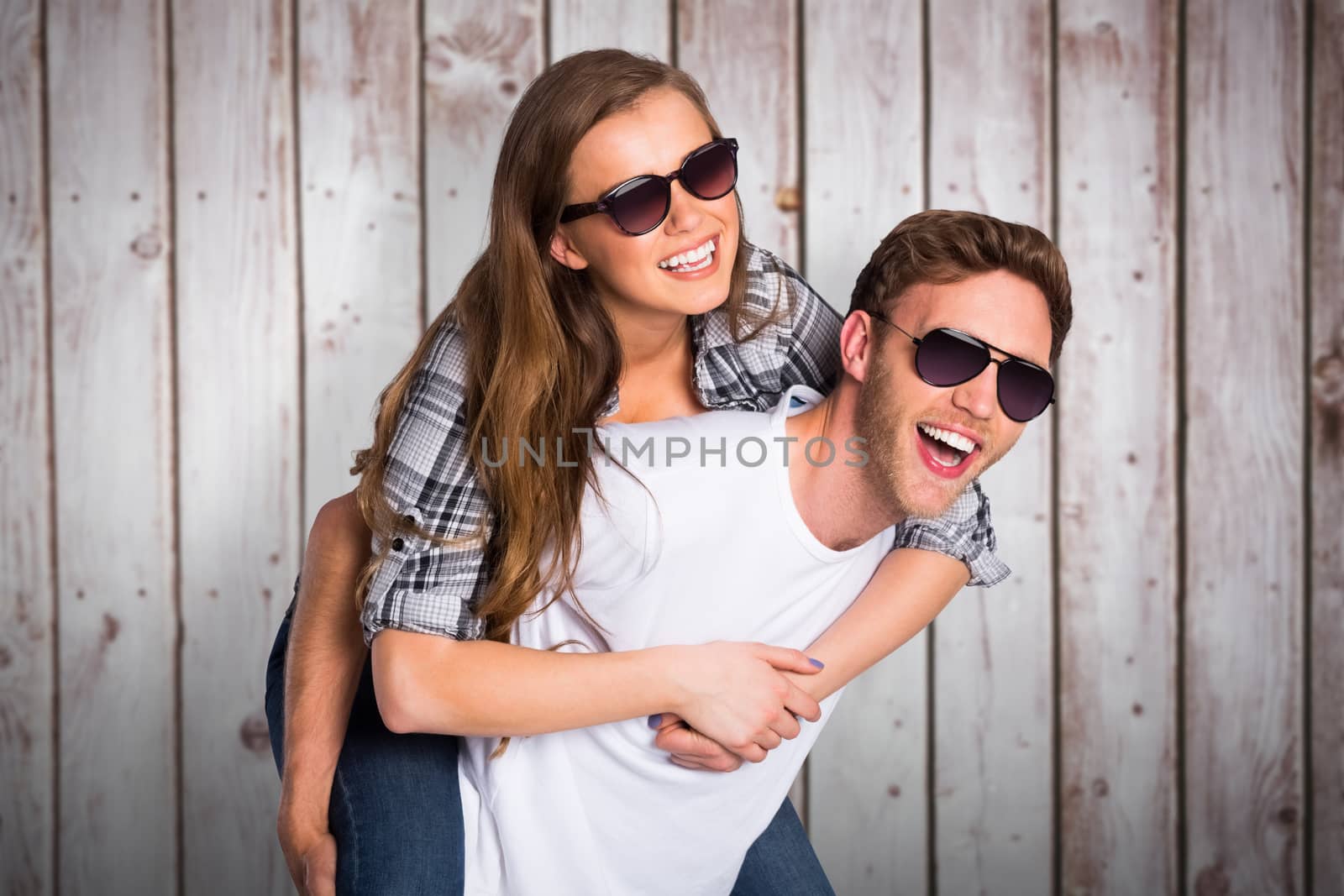 Composite image of smiling young man carrying woman by Wavebreakmedia