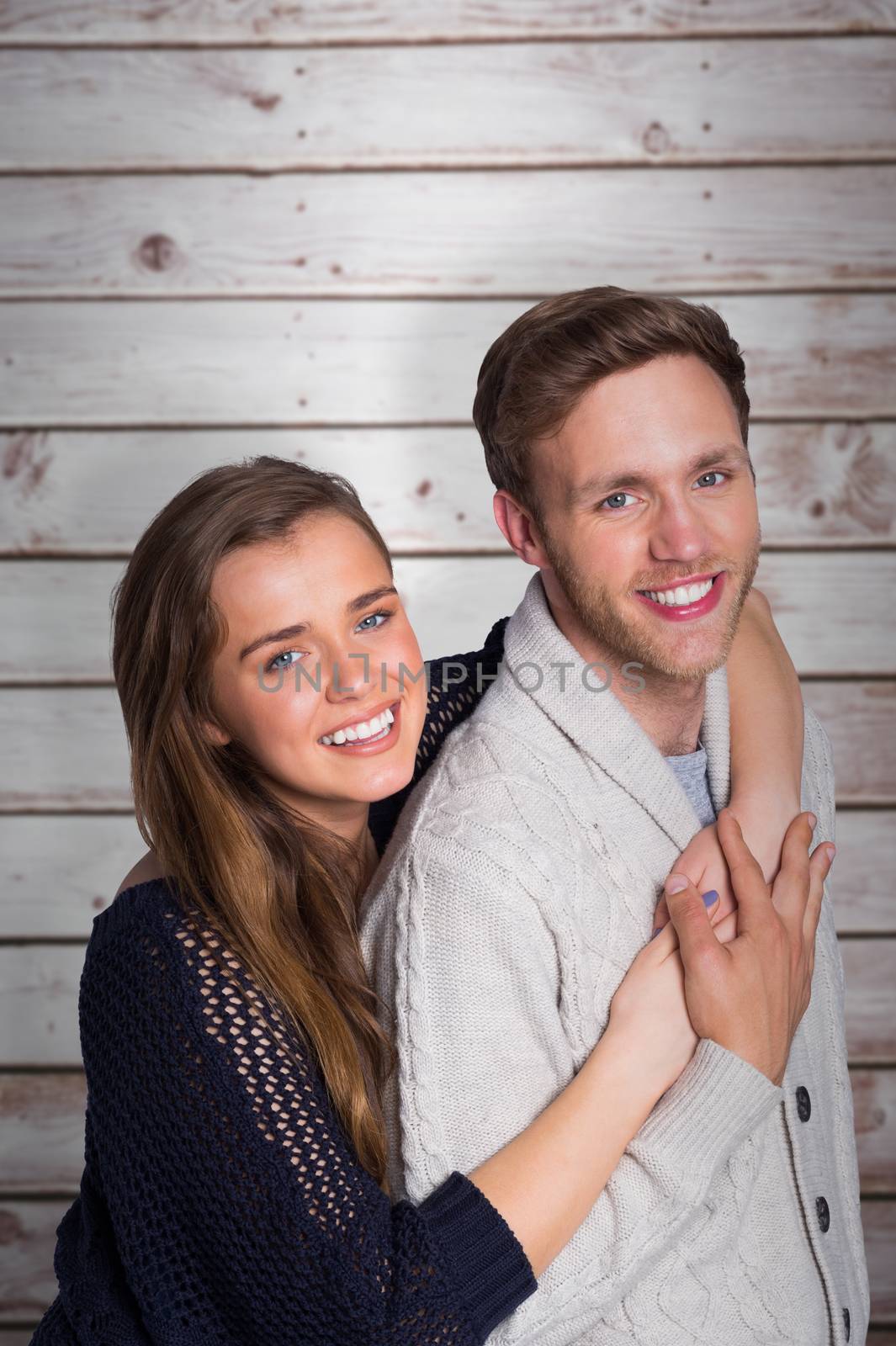 Portrait of happy young couple against wooden planks