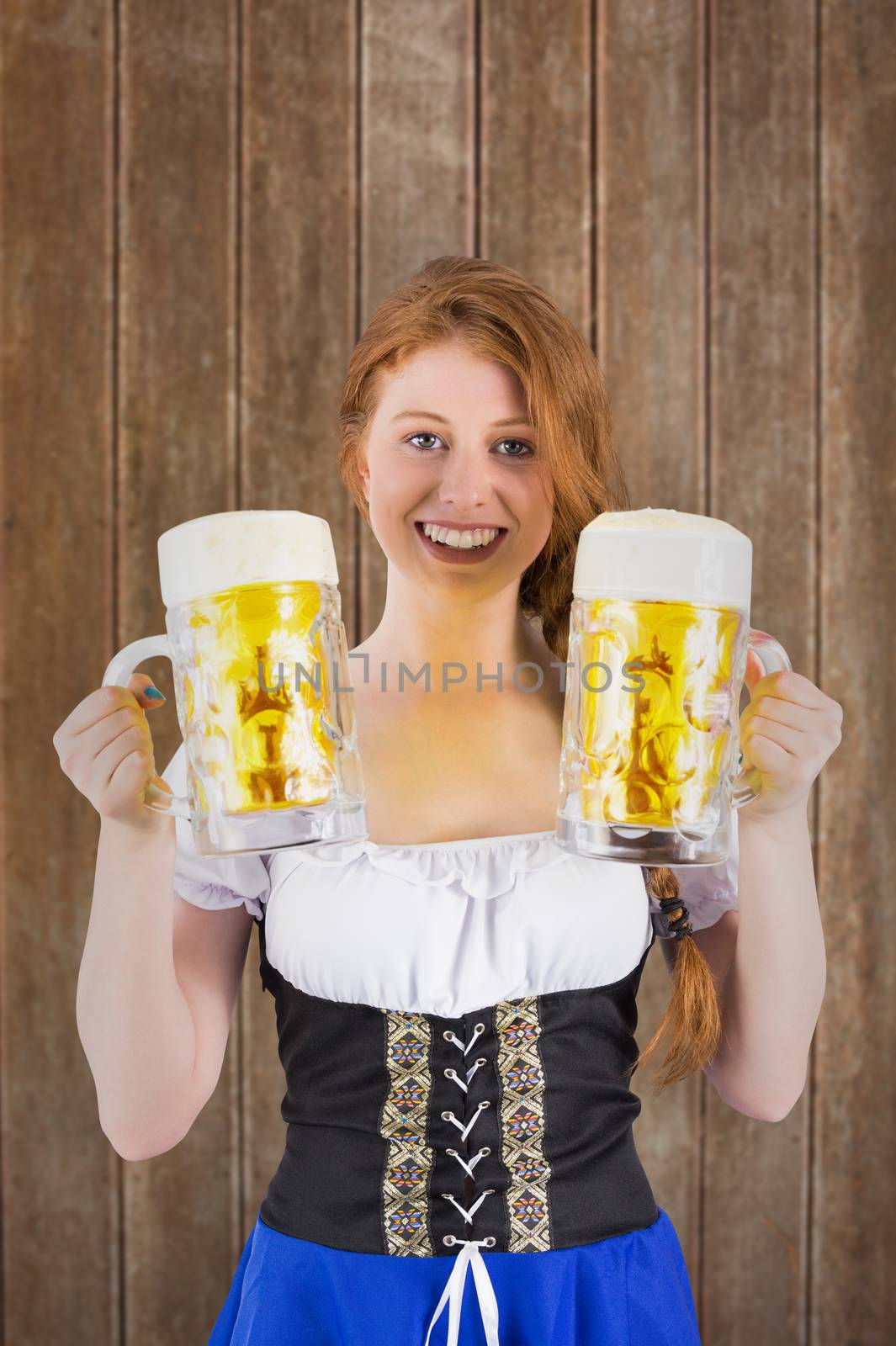 Composite image of oktoberfest girl holding jugs of beer by Wavebreakmedia