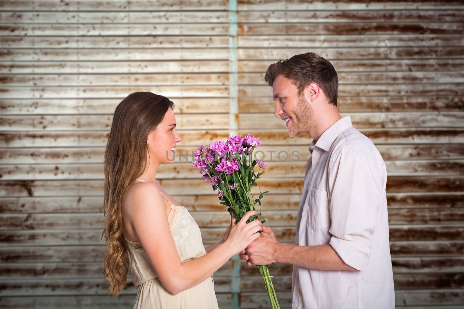Side view of couple holding flowers against wooden planks