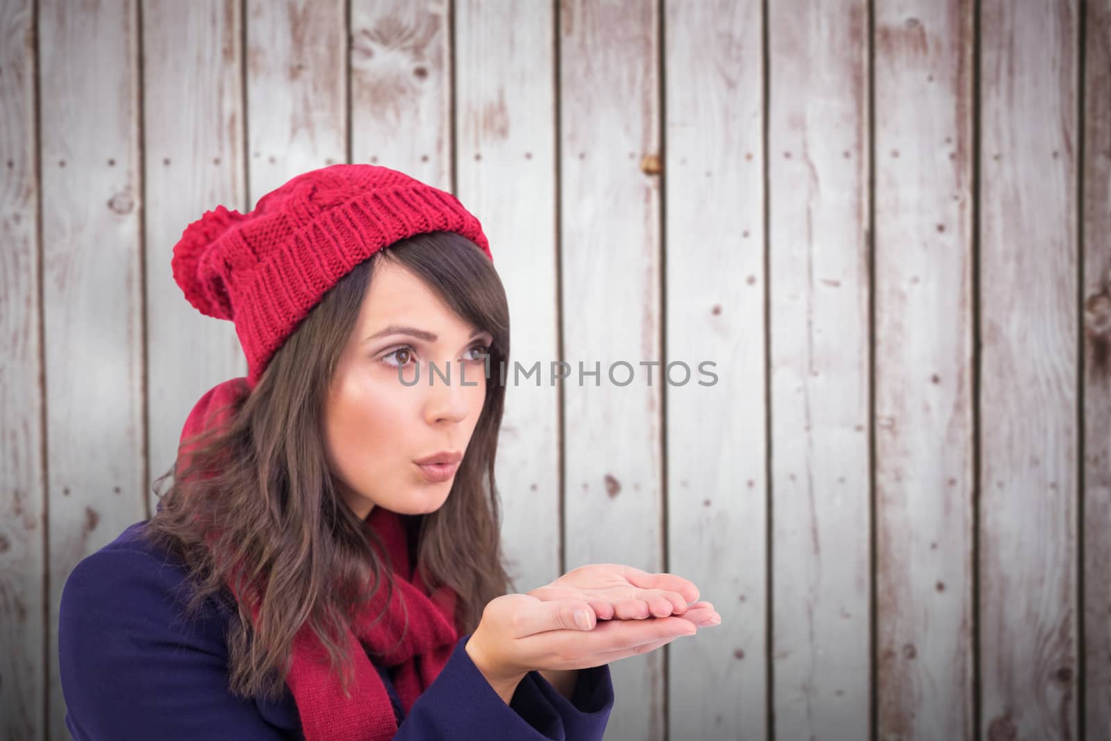 Composite image of festive brunette blowing over hands by Wavebreakmedia