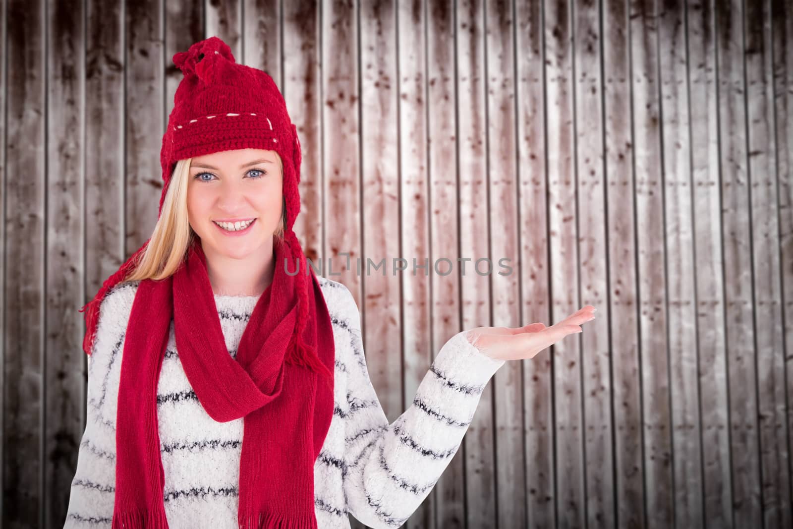 Composite image of festive blonde presenting with hand by Wavebreakmedia