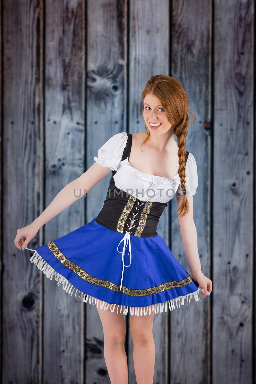 Oktoberfest girl spreading her skirt against grey wooden planks