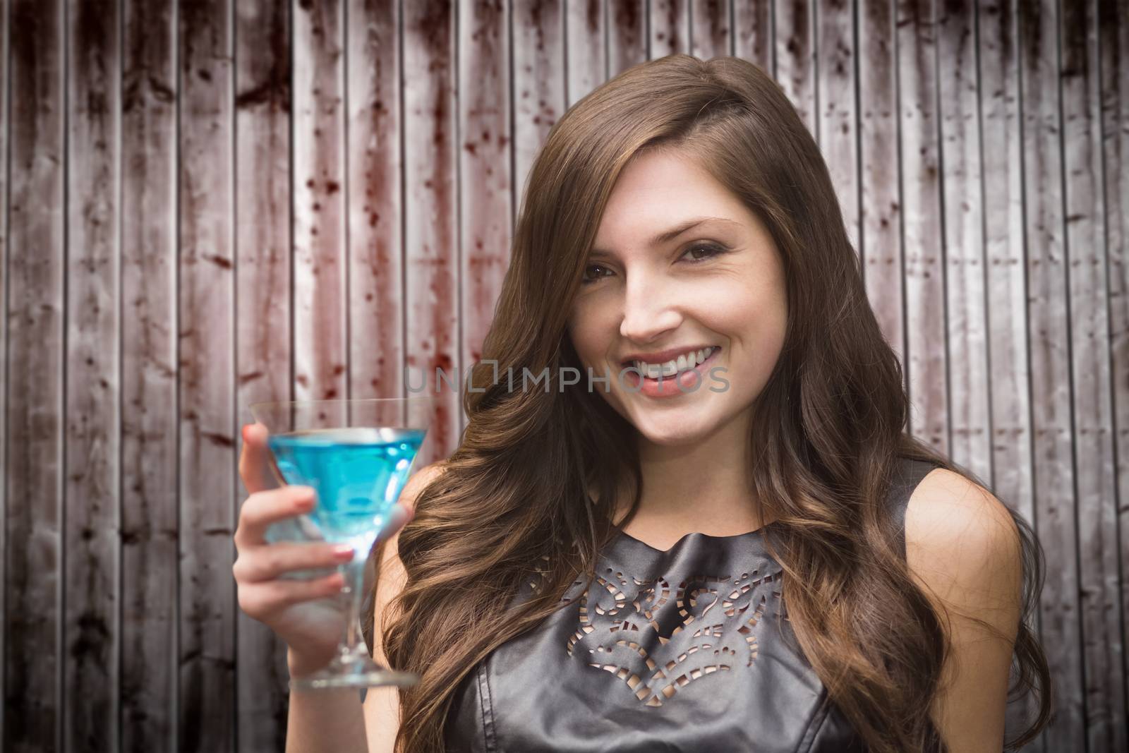 Brunette with cocktail against wooden planks