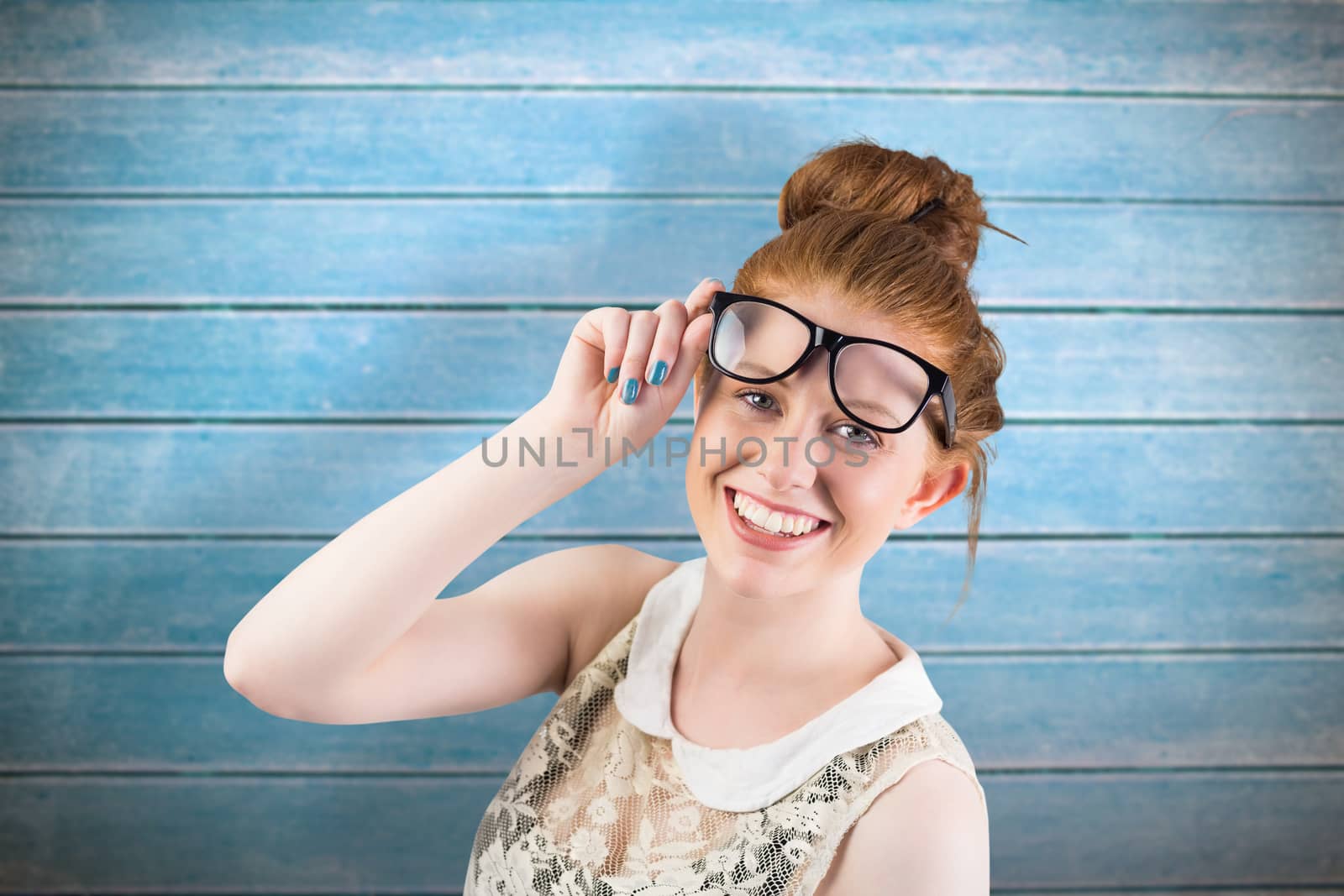 Hipster redhead smiling at camera against wooden planks