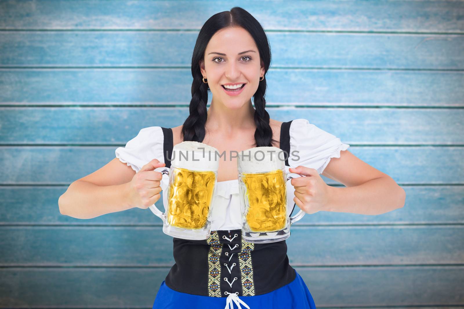 Pretty oktoberfest girl holding beer tankards against wooden planks