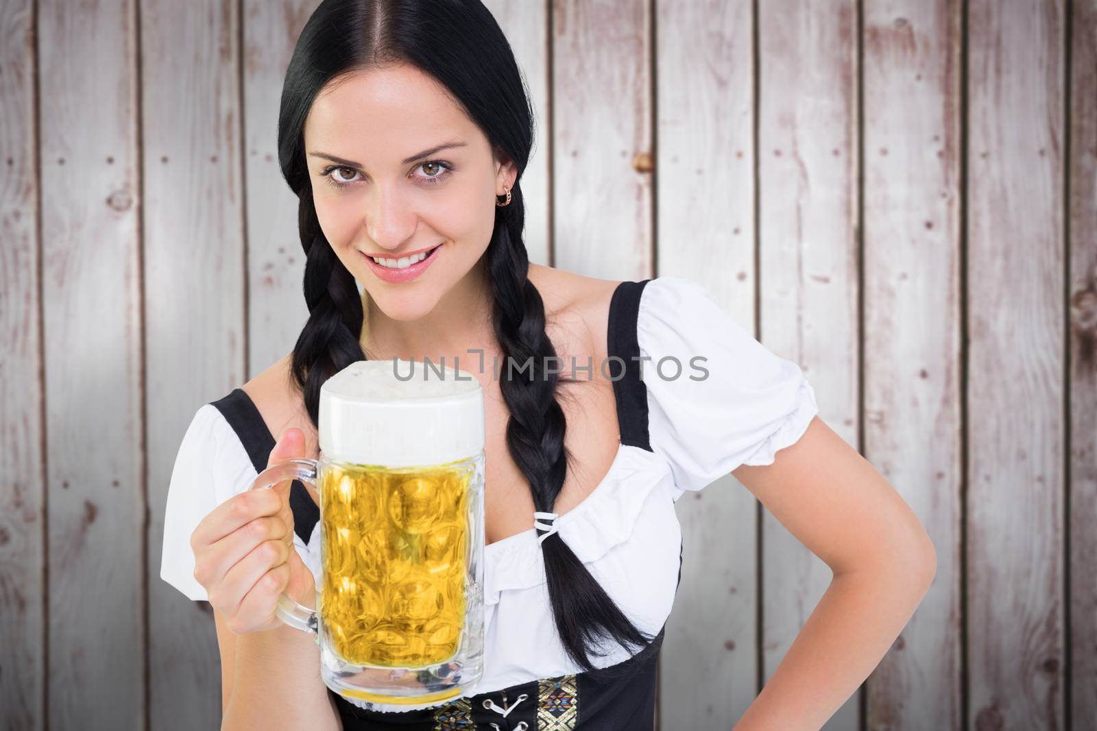 Pretty oktoberfest girl holding beer tankard against wooden planks