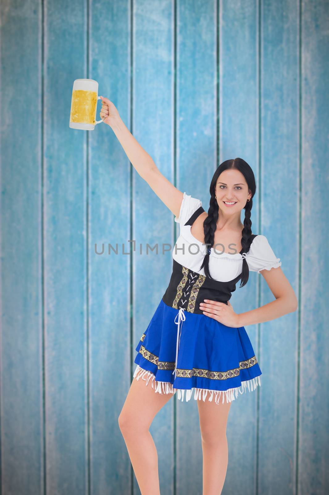 Pretty oktoberfest girl holding beer tankard against wooden planks
