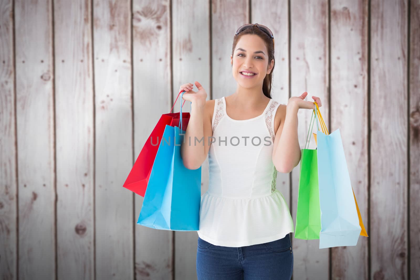 Composite image of cheerful brown hair holding shopping bags by Wavebreakmedia