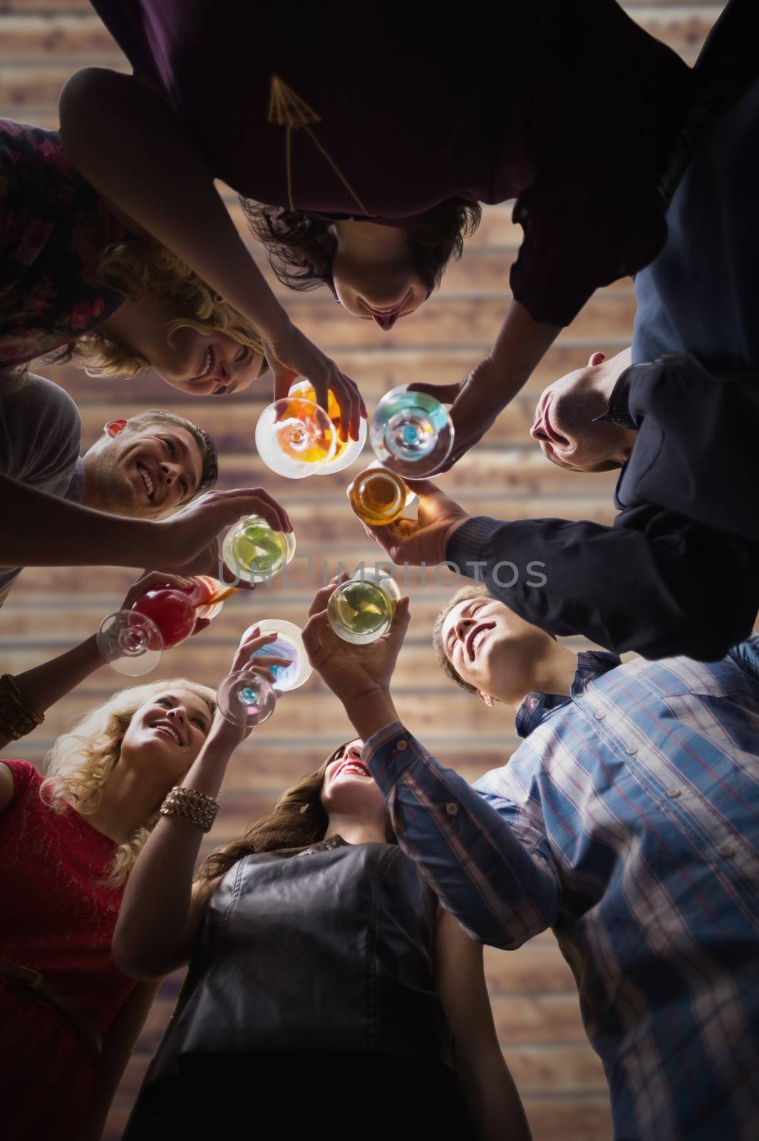 Friends toasting against wooden planks