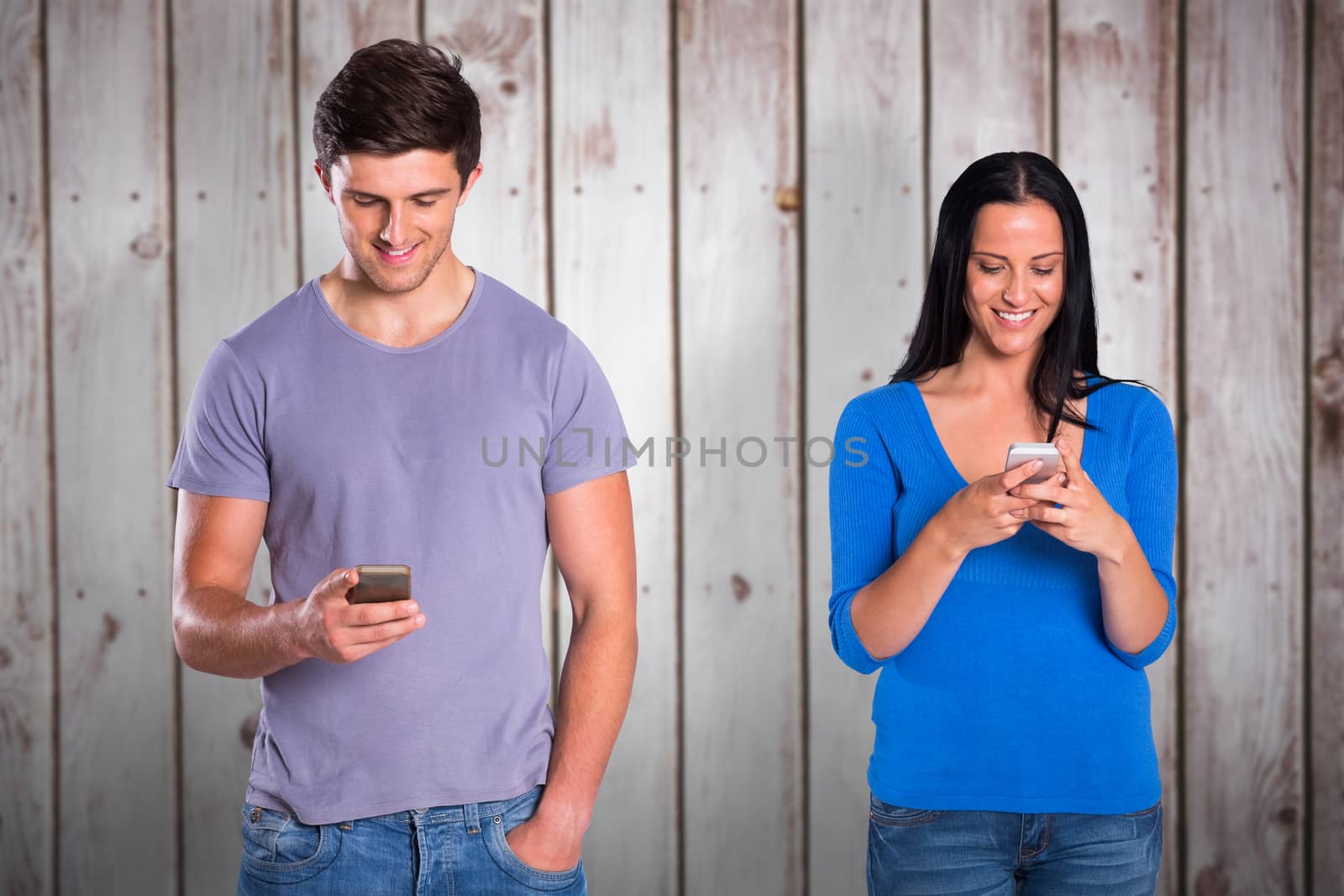 Young couple sending a text against wooden planks