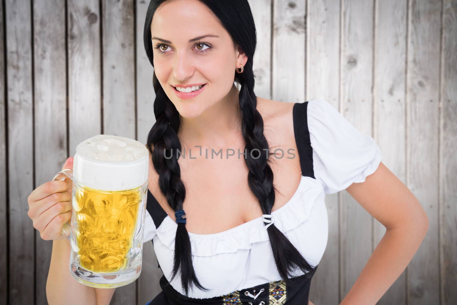 Pretty oktoberfest girl holding beer tankard against wooden planks