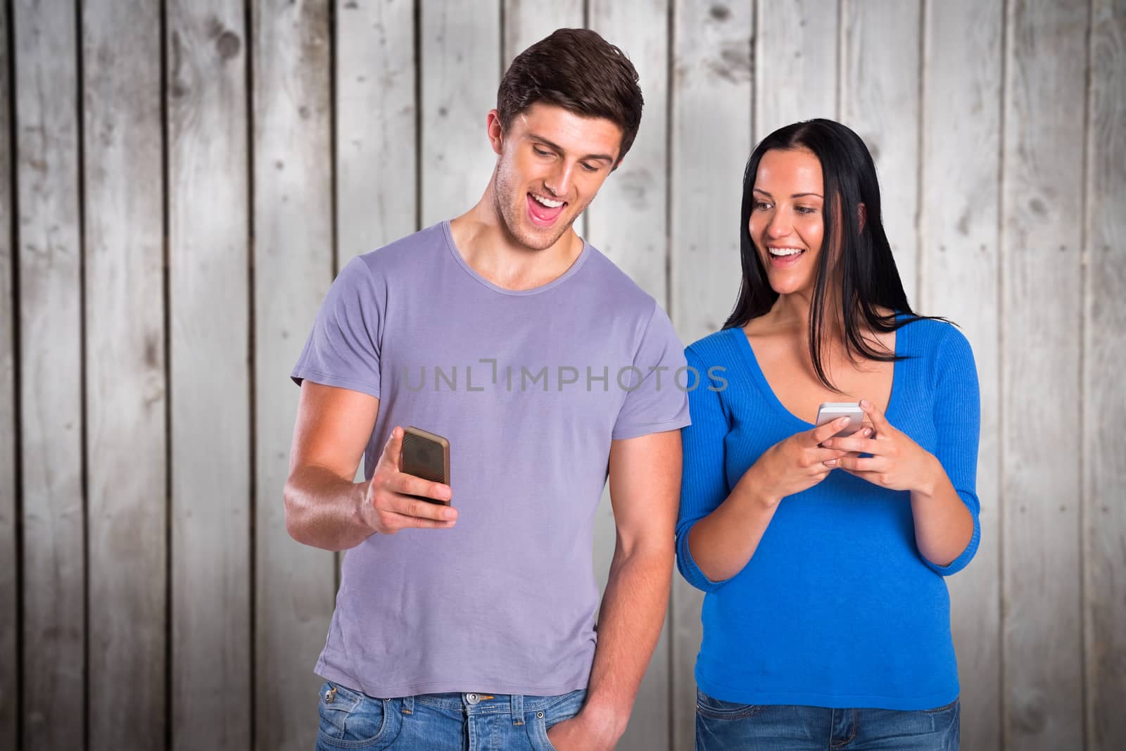 Young couple sending a text against wooden planks