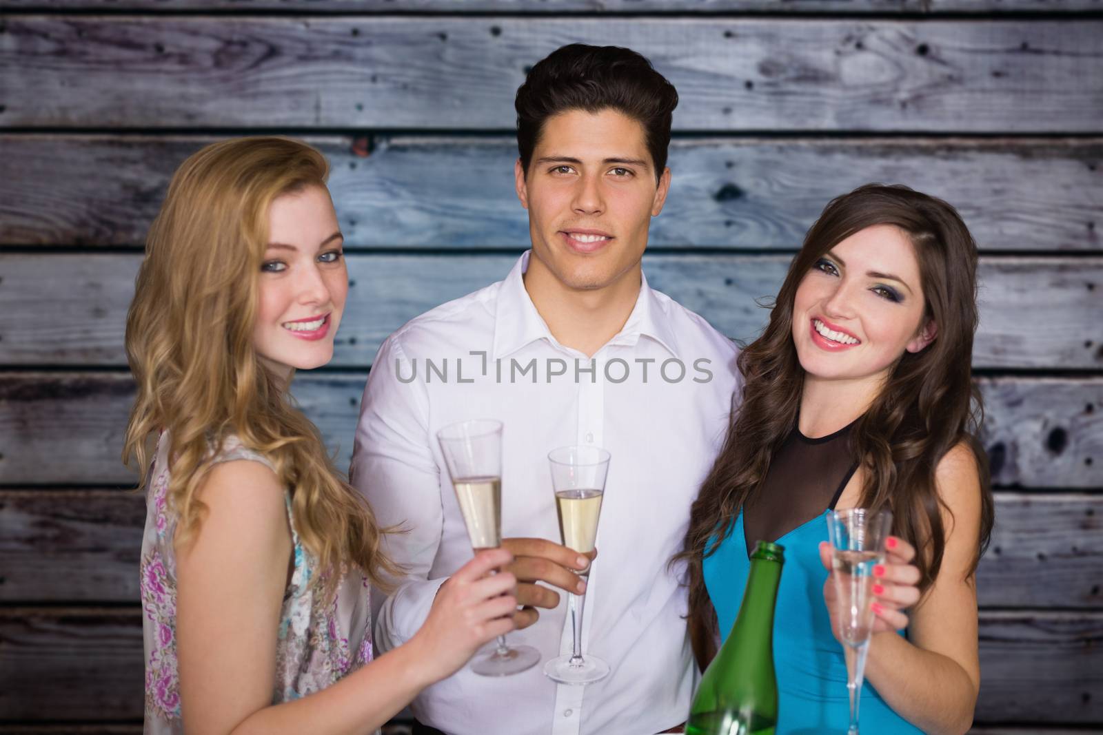Friends drinking champagne against grey wooden planks
