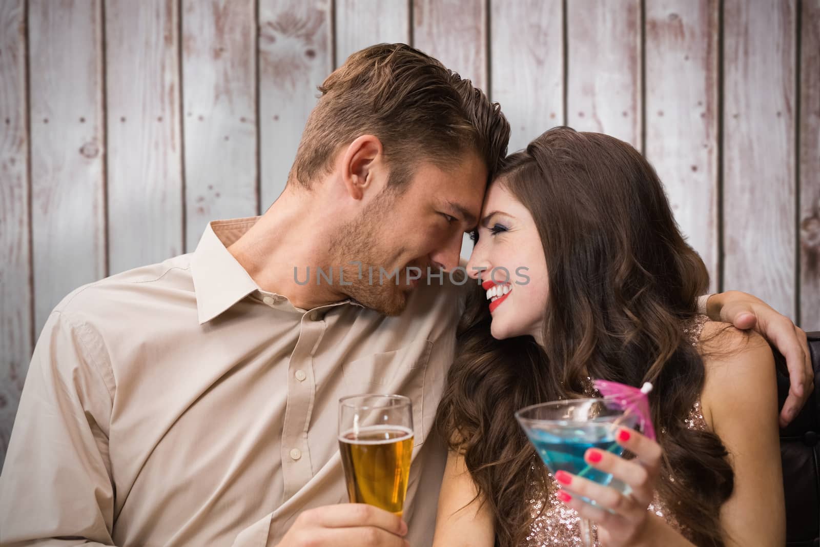 Cute couple drinking against wooden planks