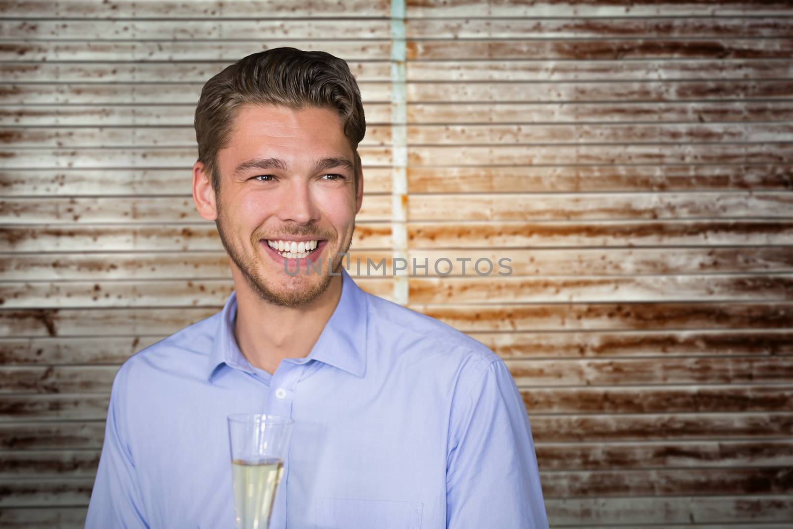 Man toasting with champagne against wooden planks