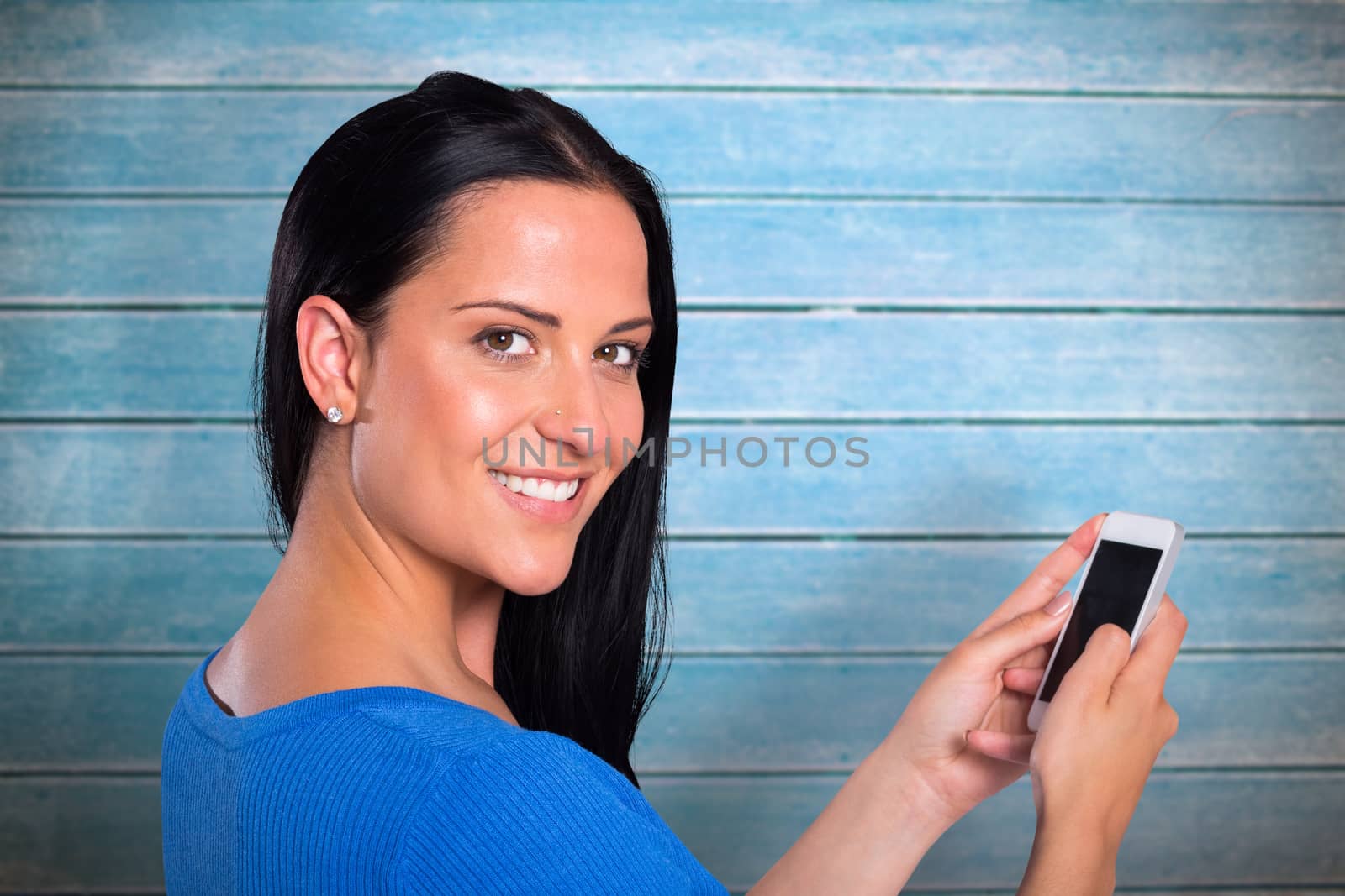 Young brunette sending a text against wooden planks