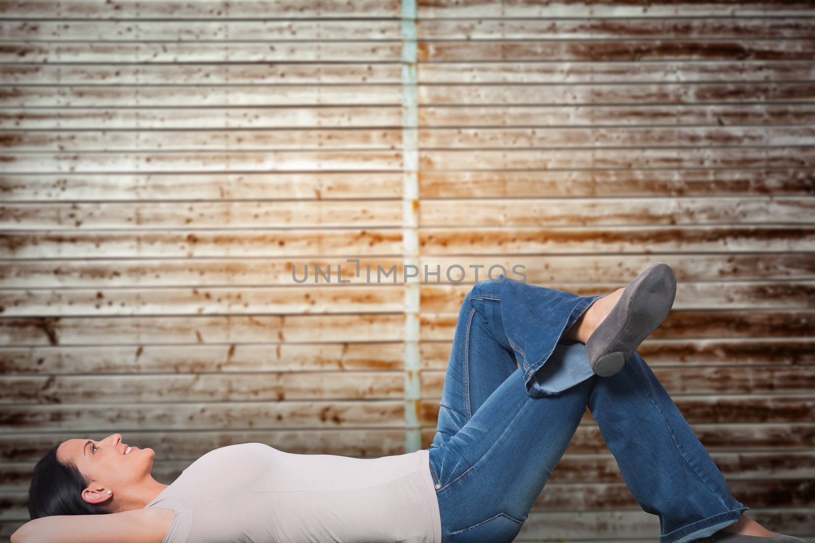 Young woman lying on floor thinking against wooden planks