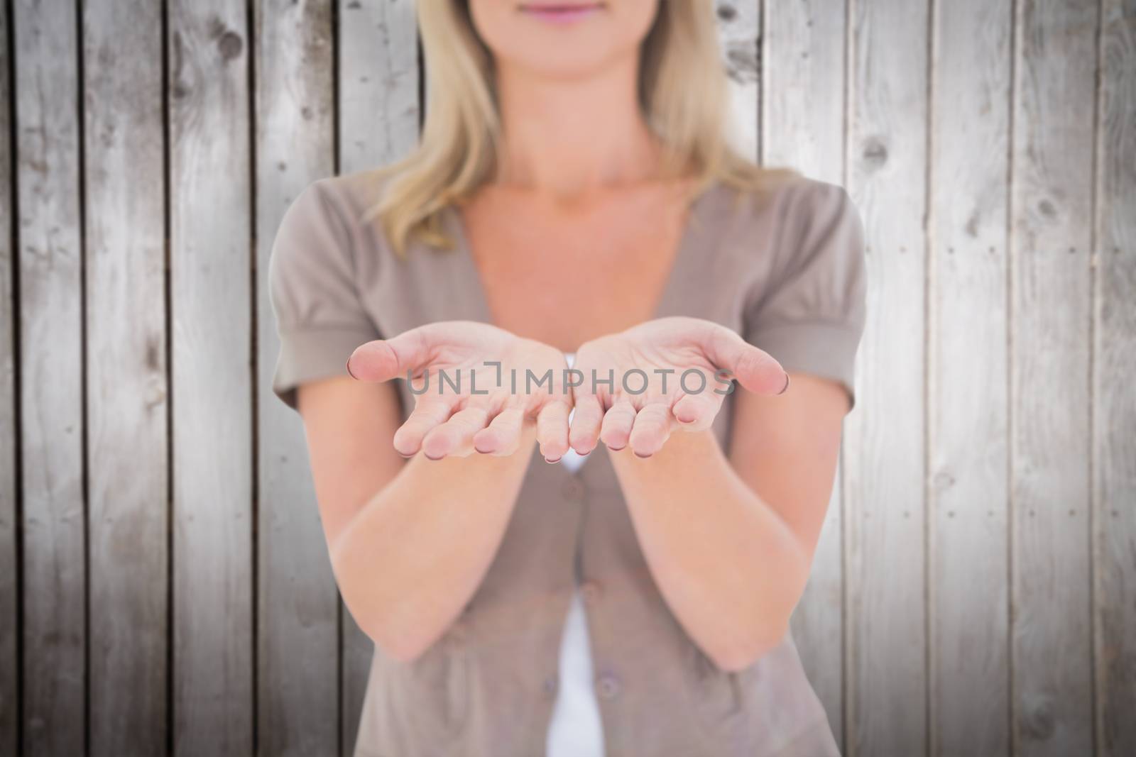 Happy blonde holding our her hands against wooden planks