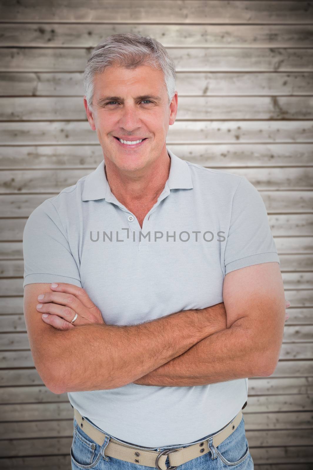 Casual man smiling at camera against wooden planks background