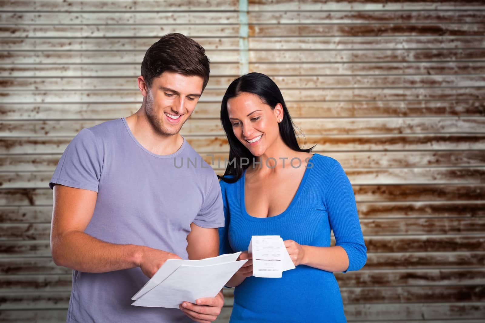 Composite image of young couple reading their bills by Wavebreakmedia