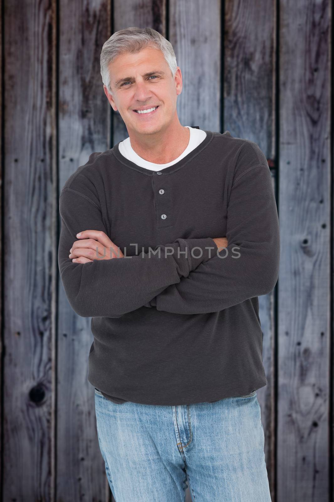Casual man smiling at camera against grey wooden planks