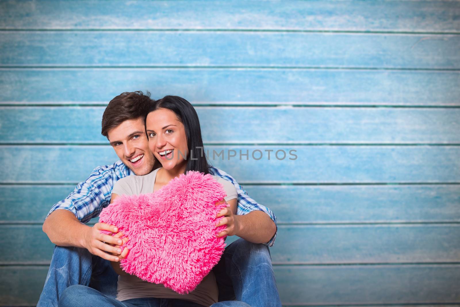 Composite image of young couple sitting on floor smiling by Wavebreakmedia