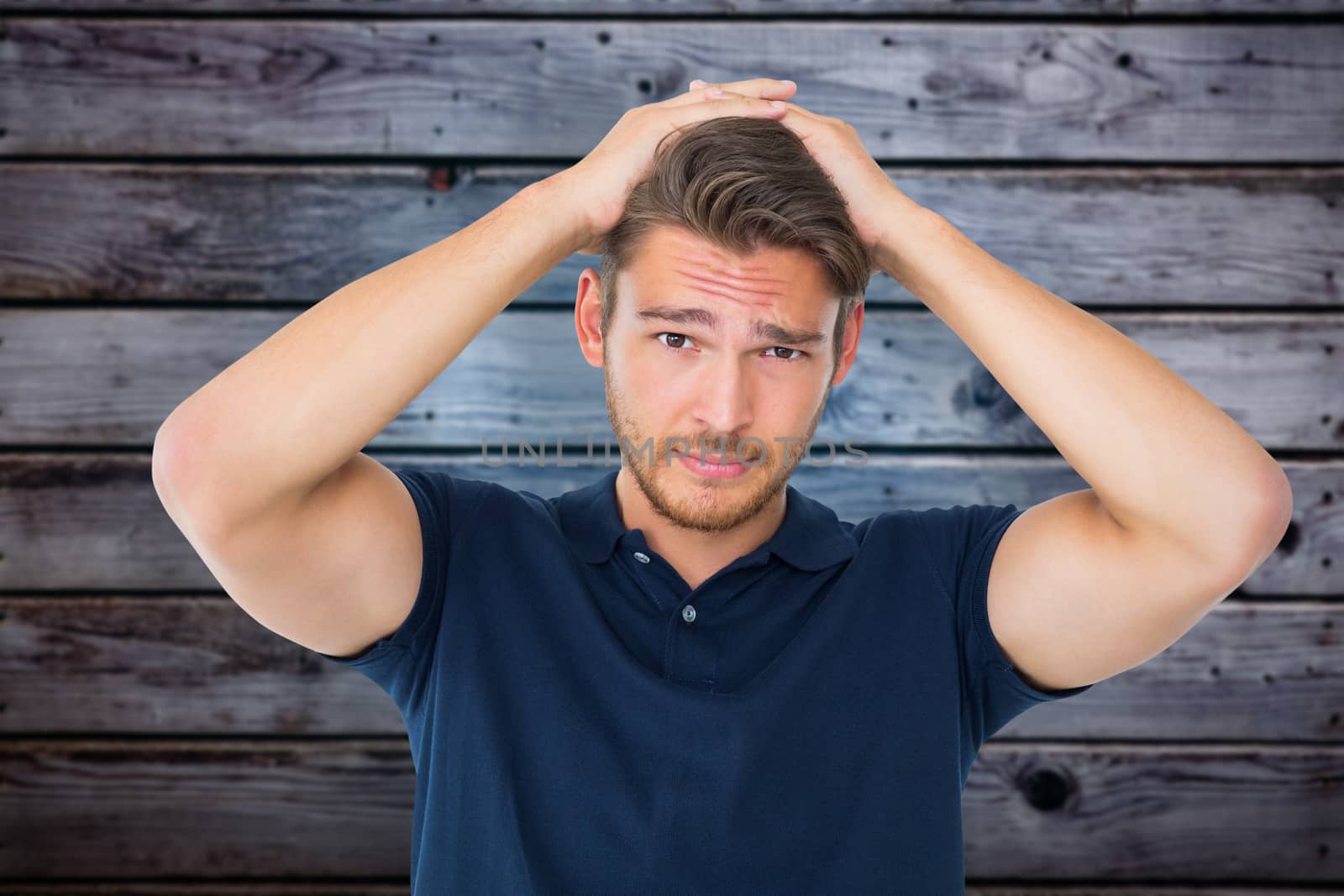 Handsome young man looking confused against grey wooden planks