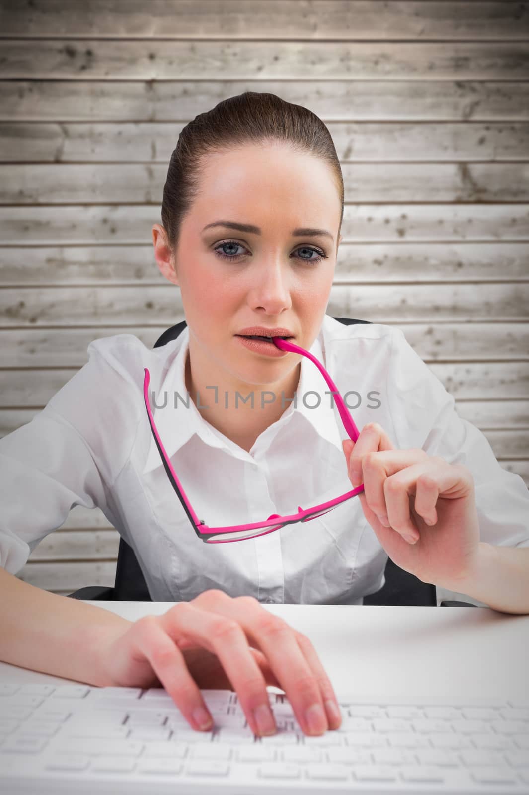 Businesswoman typing on a keyboard against wooden planks background