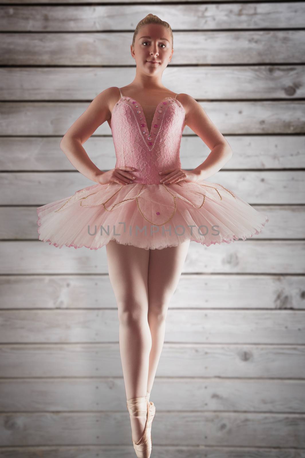 Composite image of pretty ballerina in pink standing en pointe by Wavebreakmedia