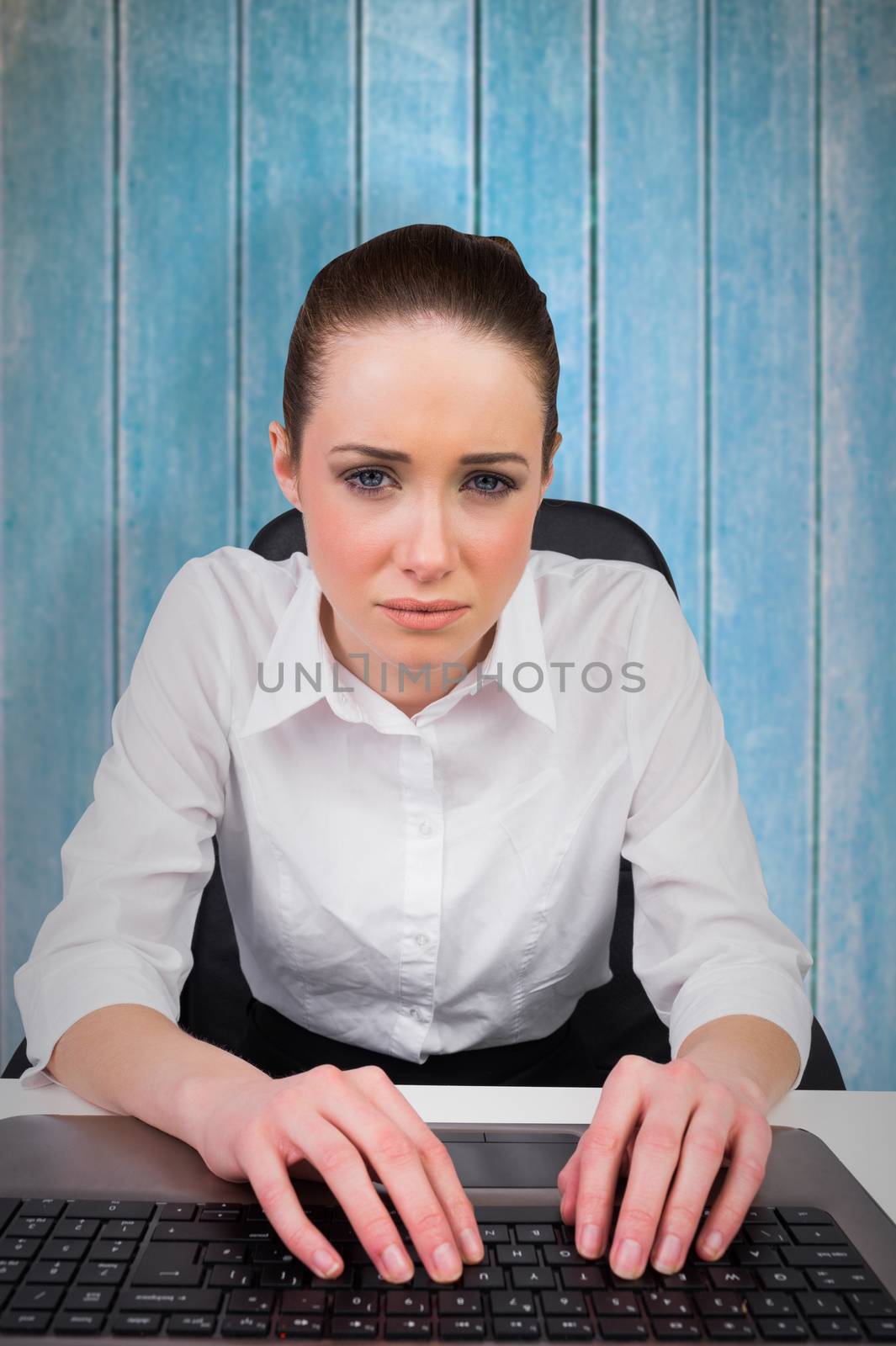 Businesswoman typing on a keyboard against wooden planks