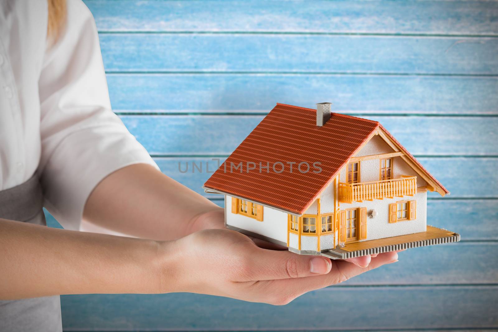 Composite image of businesswoman holding model house by Wavebreakmedia