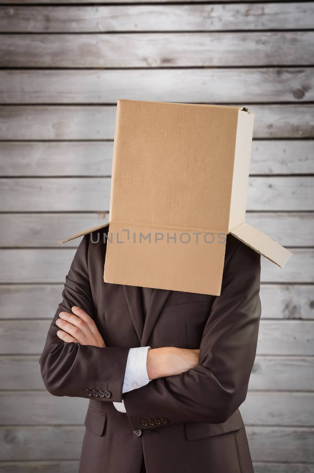 Anonymous businessman with arms crossed against wooden planks