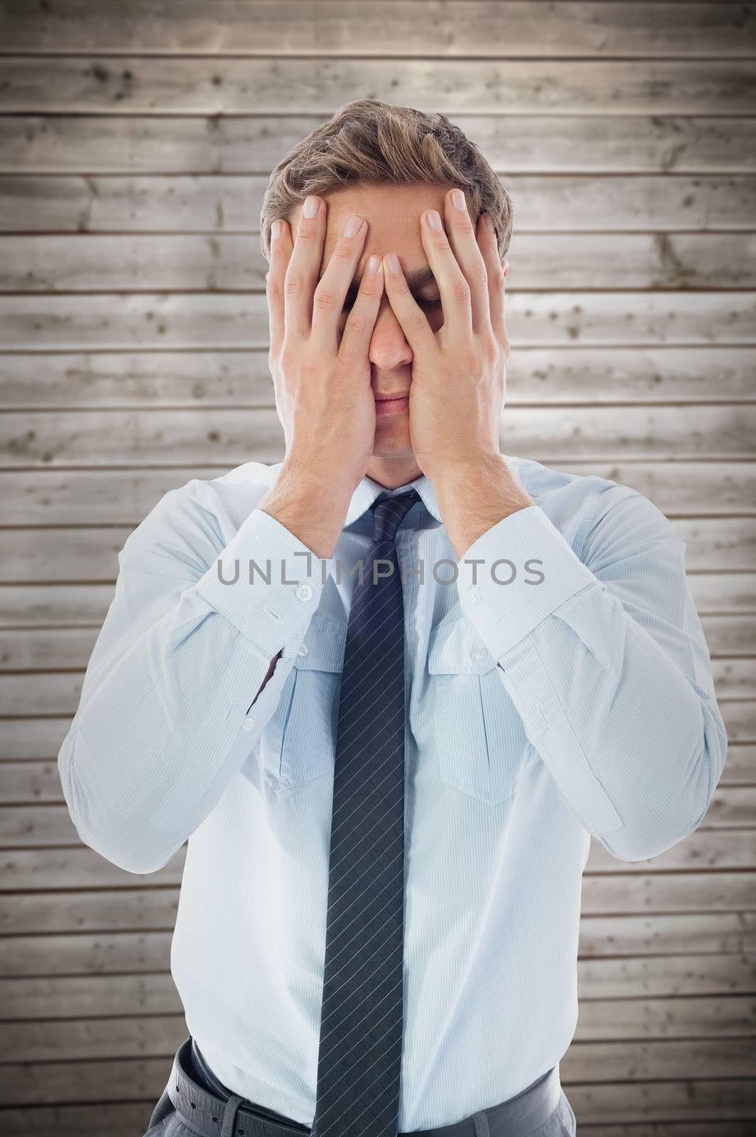 Businessman with a headache against wooden planks background