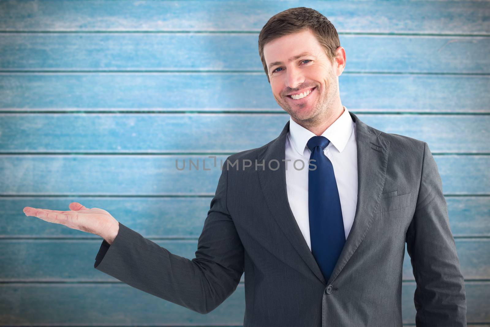 Businessman with his hand out against wooden planks