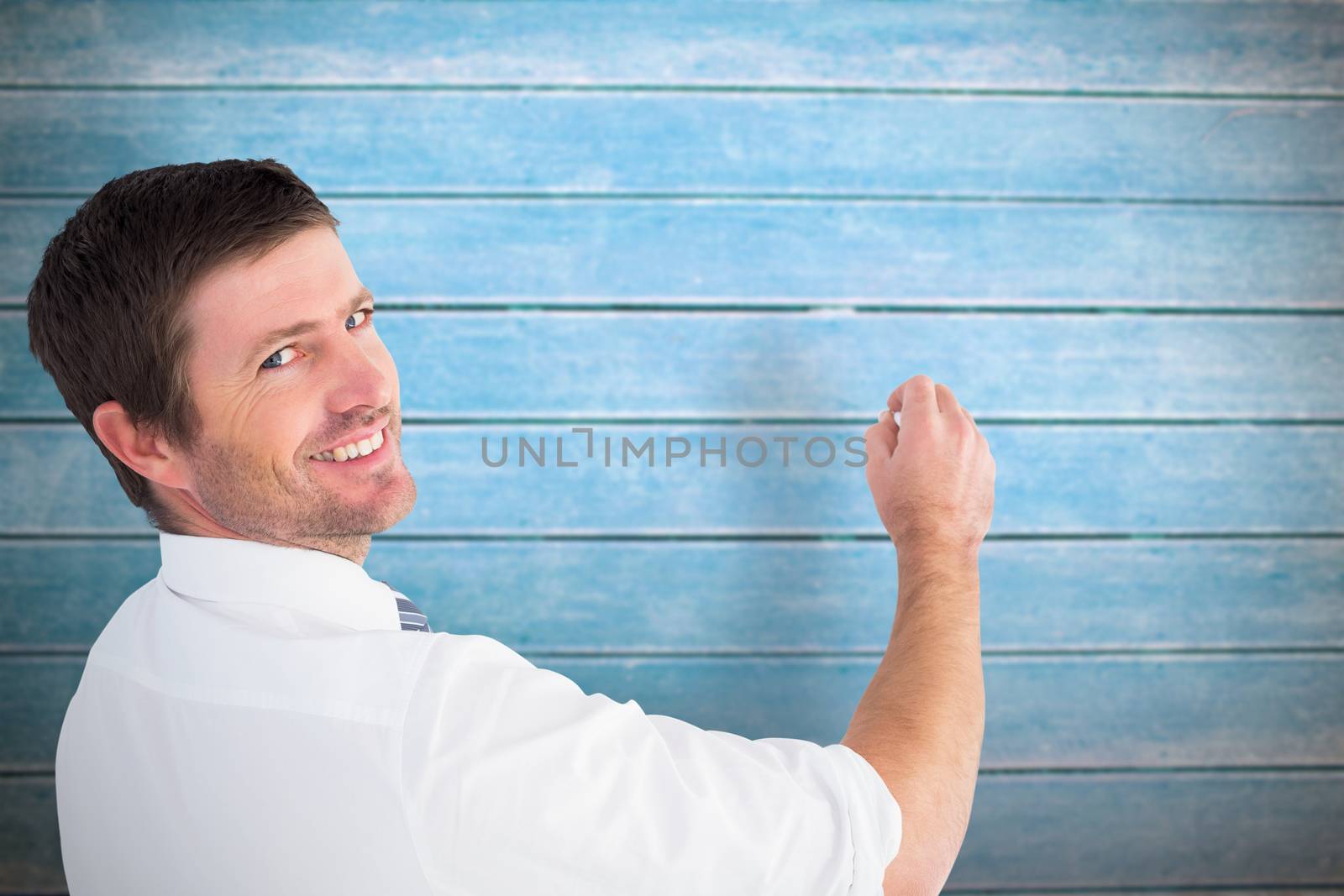 Business man writing with chalk against wooden planks