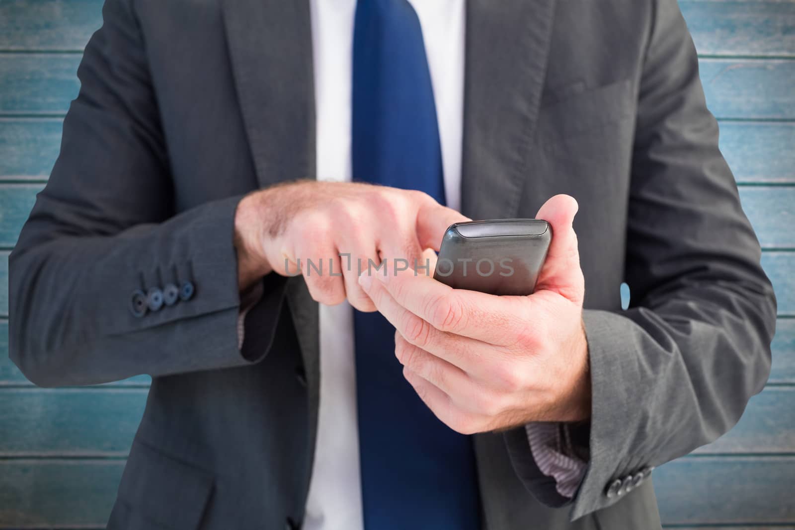 Composite image of businessman sending a text message by Wavebreakmedia