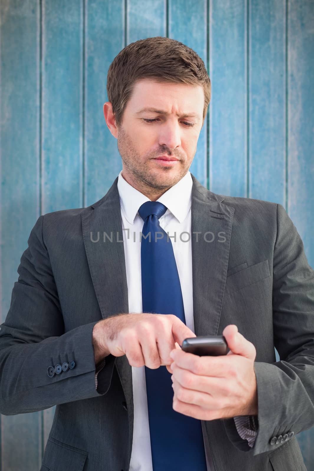 Businessman sending a text message against wooden planks