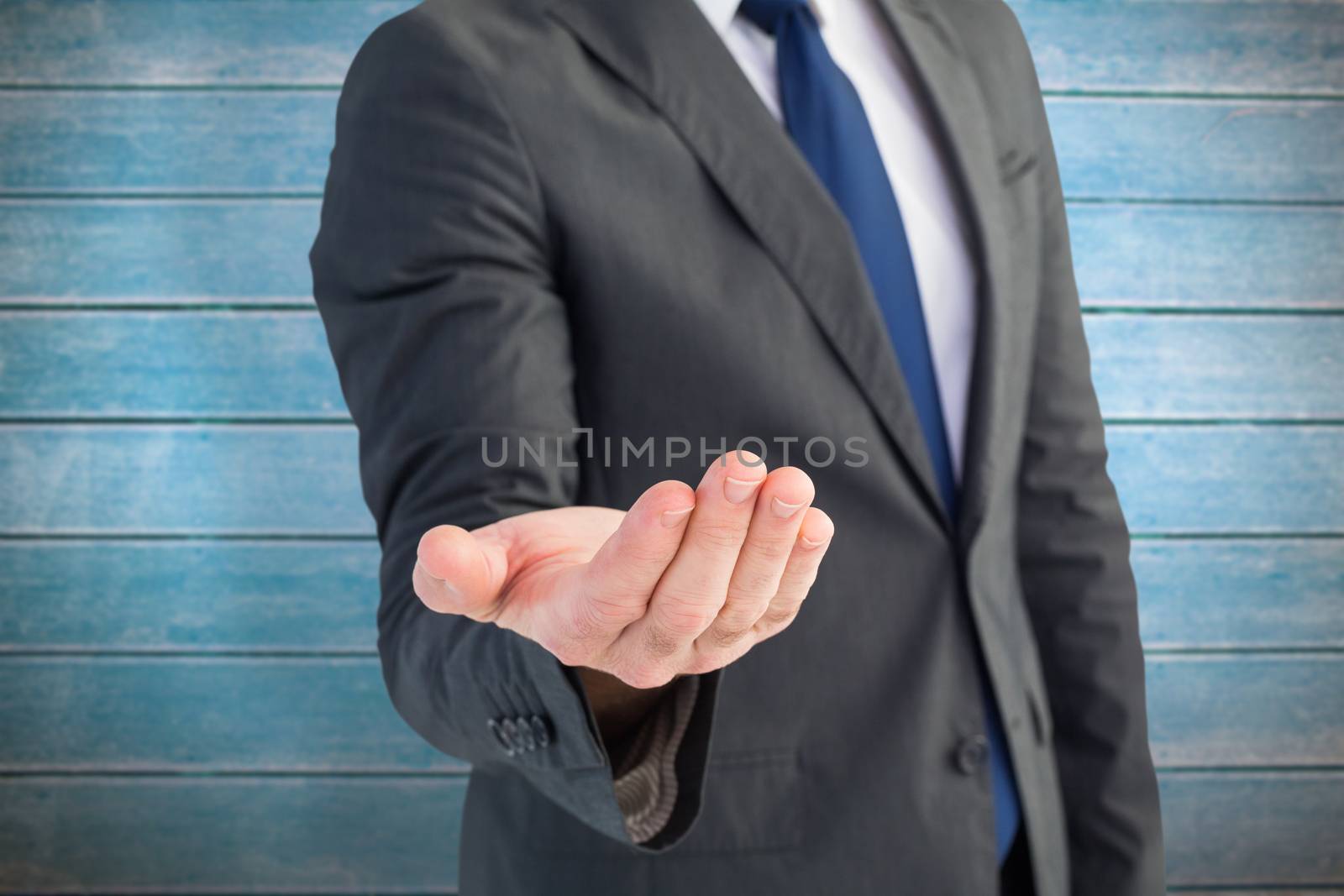 Composite image of businessman holding out his hand by Wavebreakmedia