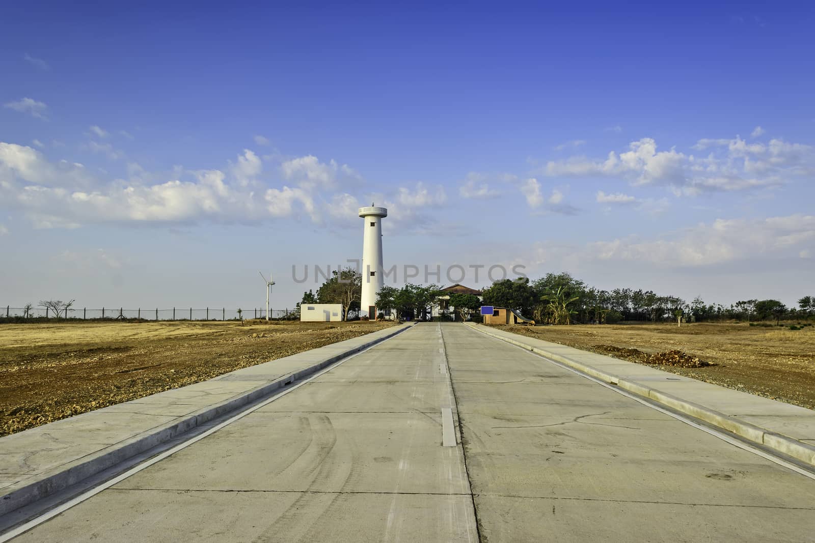 Newly built concrete road leading to a lighthouse undergoing restoration