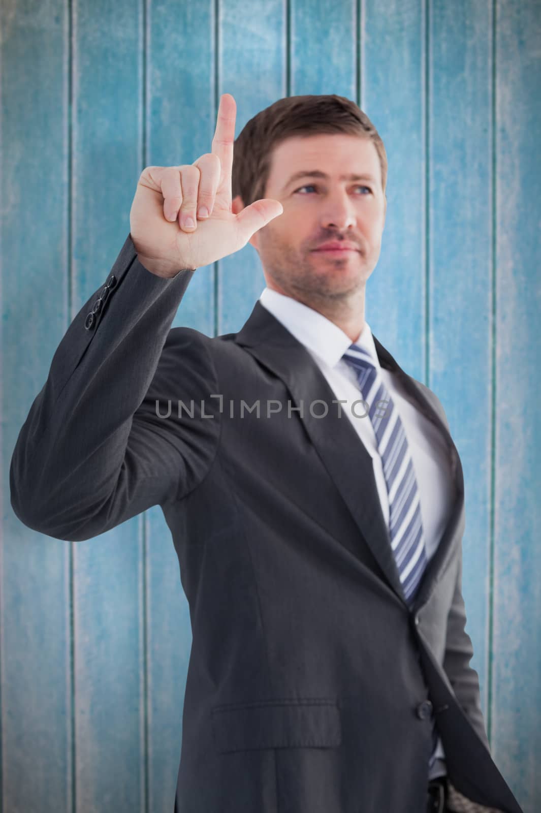 Composite image of serious businessman standing and pointing by Wavebreakmedia