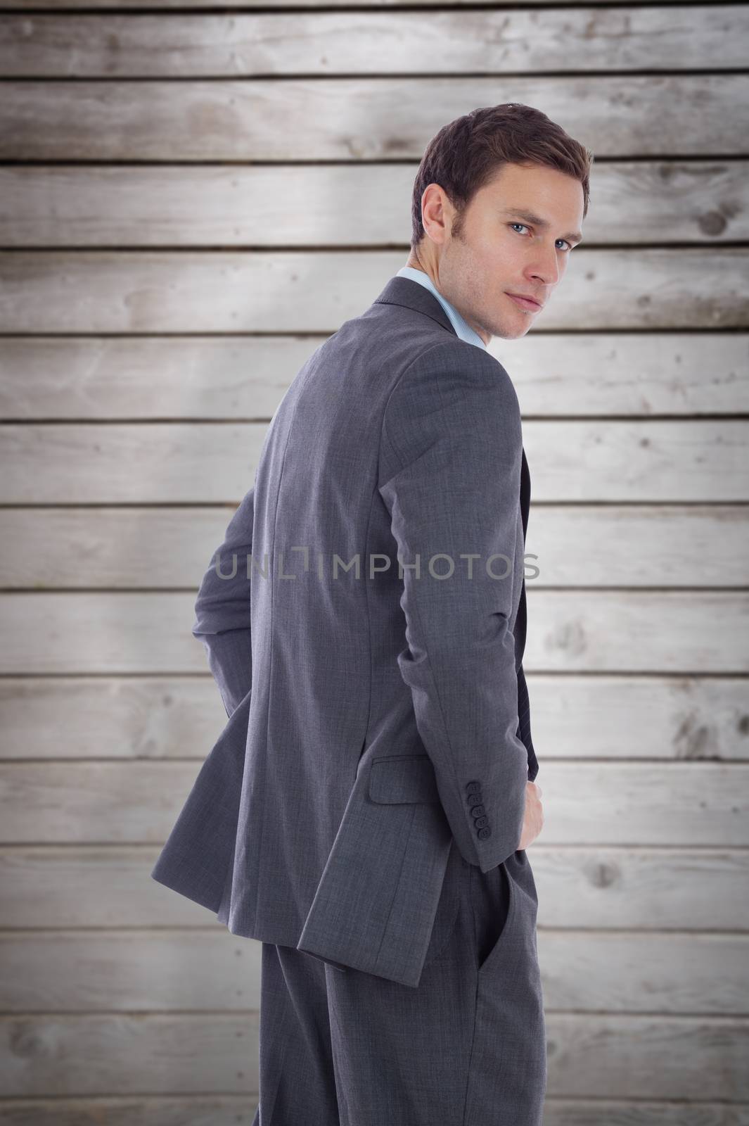 Composite image of serious businessman with hands on hips by Wavebreakmedia